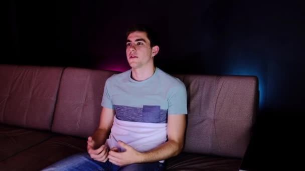 笑顔の若い大人の男Vloggerは カメラの話を見てオンラインチャットライブビデオ会議コールを行います 感情的な男の叫びと負の感情を表現ジェスチャーの肖像 自宅でソファに座って — ストック動画