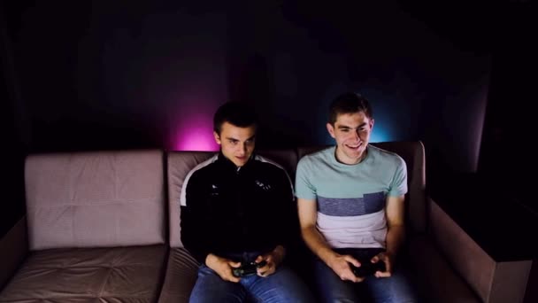 Dois Jovens Riem Meninos Sentados Sofá Frente Jogando Console Jogos — Vídeo de Stock