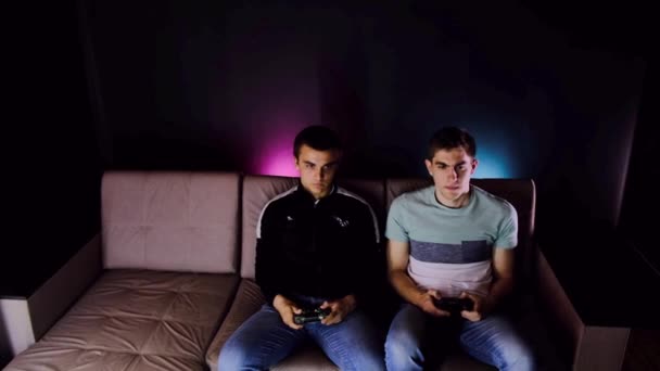 Dos Chicos Jóvenes Están Sentados Sofá Frente Televisor Jugando Una — Vídeos de Stock