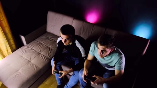 Dos Chicos Jóvenes Están Sentados Sofá Frente Televisor Jugando Una — Vídeos de Stock