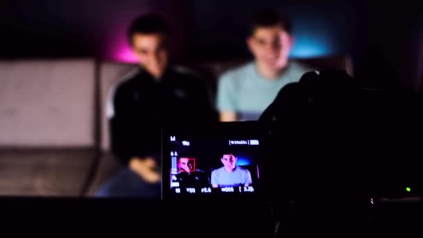 Przechylona Kamera Nagrywa Dwóch Młodych Facetów Siedzących Kanapie Przed Telewizorem — Wideo stockowe