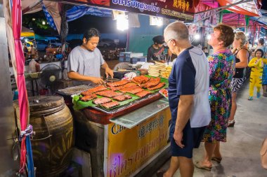Pattaya gece piyasada deniz ürünleri satan sokak gıda satıcı