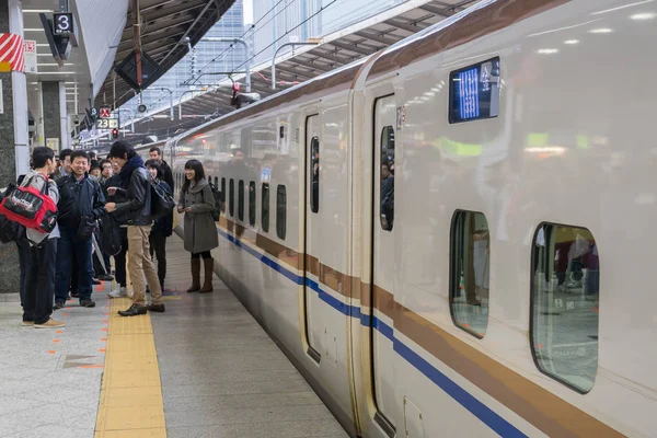 Pasajeros esperando el tren bala Shinkansen en la estación de tren de Tokio — Foto de Stock