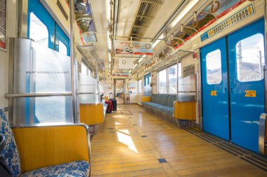 Fujikyu tren istasyonunda tren oturan yolcular.