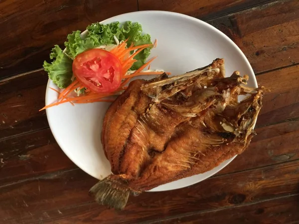 Жареная рыба на тарелке с соусом — стоковое фото