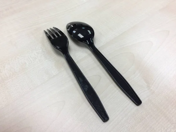 Black plastic spoon and fork — Stock Photo, Image