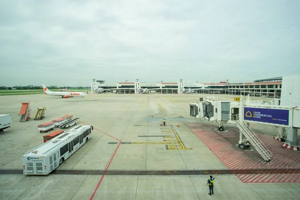 Équipage au sol dirigeant un avion entrant en position pour rencontrer un pont jet-way à l'aéroport international de Don Mueang (DMK ) — Photo