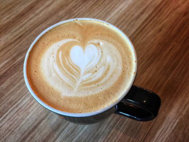 Bir fincan kahve masada üstüne krema ile