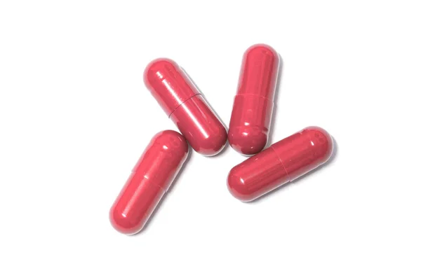 Röd färg piller kapslar på bakgrund — Stockfoto