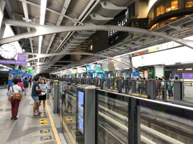Bangkok, Tayland - 06 Aralık 2017: Demiryolu Seyahati bir şehir merkezi istasyonunda yaklaşan bir Bts Skytrain bekleyin. Tay başkentin Bts raylı toplu taşıma sistemi 600.000 yolcular her gün hizmet vermektedir