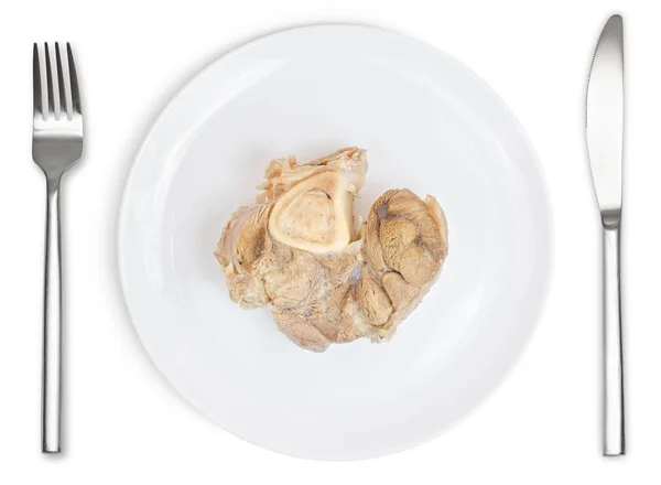 Варёная свинина на тарелке с ножом и вилкой изолирована — стоковое фото