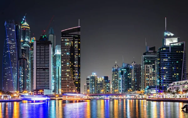 Skyline of Dubai Marina at night reflected in water