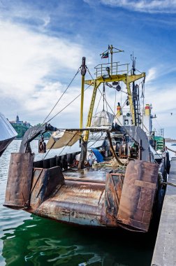 Eski paslı balıkçı gemisi limana demirlemiş..