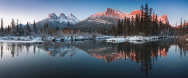 Bow River 'daki Üç Kız Kardeş Tepesi' nin neredeyse mükemmel bir yansıması. Canmore yakınlarında, Alberta Kanada. Kış mevsimi yaklaşıyor. Ayı ülkesi. Güzel manzara arka plan kavramı.