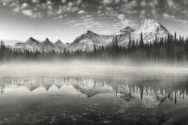 Bow River 'daki Rocky dağlarının neredeyse mükemmel bir yansıması. Canmore yakınlarında, Alberta Kanada. Kış mevsimi yaklaşıyor. Ayı ülkesi. Güzel manzara arka plan kavramı.