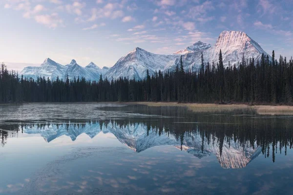 Bow River 'daki Rocky dağlarının neredeyse mükemmel bir yansıması. Canmore yakınlarında, Alberta Kanada. Kış mevsimi yaklaşıyor. Ayı ülkesi. Güzel manzara arka plan kavramı.