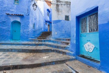 Chefchaouen, Fas, Afrika 'daki geleneksel ve tipik mimari detaylar ve mavi duvarlı ve çeşitli nesnelerle süslenmiş mavi Medine' nin güzel caddesi..
