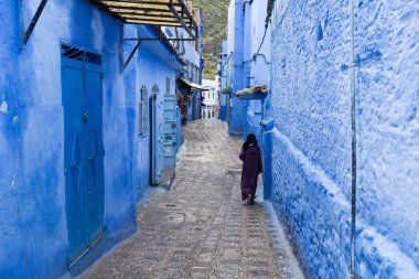 Chefchaouen, Fas, Afrika 'daki geleneksel ve tipik mimari detaylar ve mavi duvarlı ve çeşitli nesnelerle süslenmiş mavi Medine' nin güzel caddesi..