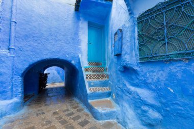 Chefchaouen, Fas, Afrika 'daki geleneksel ve tipik mimari detaylar ve mavi duvarlı ve çeşitli nesnelerle süslenmiş mavi Medine' nin güzel caddesi..