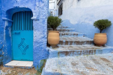 Chefchaouen, Fas, Afrika 'daki geleneksel ve tipik mimari detaylar ve mavi duvarlı ve çeşitli nesnelerle süslenmiş mavi Medine' nin güzel caddesi..