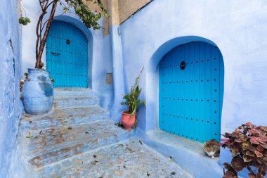 Chefchaouen, Fas, Afrika 'daki geleneksel ve tipik mimari detaylar ve mavi duvarlı ve çeşitli nesnelerle süslenmiş mavi Medine' nin güzel caddesi..