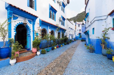 Chefchaouen, Fas, Afrika 'daki geleneksel ve tipik mimari detaylar ve mavi duvarlı ve çeşitli nesnelerle süslenmiş mavi Medine' nin güzel caddesi..