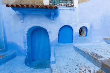 Chefchaouen, Fas, Afrika 'daki geleneksel ve tipik mimari detaylar ve mavi duvarlı ve çeşitli nesnelerle süslenmiş mavi Medine' nin güzel caddesi..