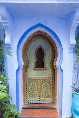 Chefchaouen, Fas, Afrika 'daki geleneksel ve tipik mimari detaylar ve mavi duvarlı ve çeşitli nesnelerle süslenmiş mavi Medine' nin güzel caddesi..