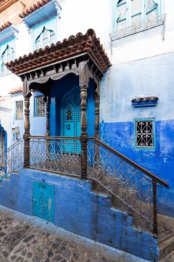 Chefchaouen, Fas, Afrika 'daki geleneksel ve tipik mimari detaylar ve mavi duvarlı ve çeşitli nesnelerle süslenmiş mavi Medine' nin güzel caddesi..