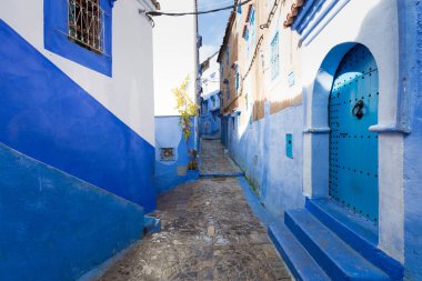 Chefchaouen, Fas, Afrika 'daki geleneksel ve tipik mimari detaylar ve mavi duvarlı ve çeşitli nesnelerle süslenmiş mavi Medine' nin güzel caddesi..