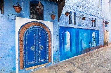 Chefchaouen, Fas, Afrika 'daki geleneksel ve tipik mimari detaylar ve mavi duvarlı ve çeşitli nesnelerle süslenmiş mavi Medine' nin güzel caddesi..