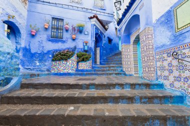 Chefchaouen, Fas, Afrika 'daki geleneksel ve tipik mimari detaylar ve mavi duvarlı ve çeşitli nesnelerle süslenmiş mavi Medine' nin güzel caddesi..