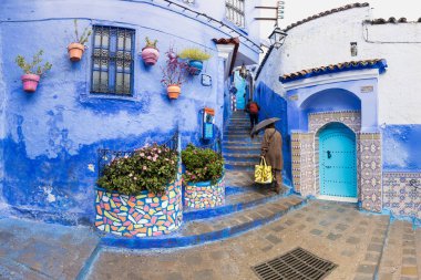 Chefchaouen, Fas, Afrika 'daki geleneksel ve tipik mimari detaylar ve mavi duvarlı ve çeşitli nesnelerle süslenmiş mavi Medine' nin güzel caddesi..