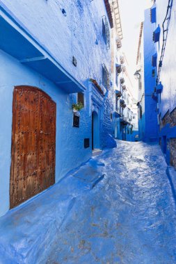 Chefchaouen, Fas, Afrika 'daki geleneksel ve tipik mimari detaylar ve mavi duvarlı ve çeşitli nesnelerle süslenmiş mavi Medine' nin güzel caddesi..