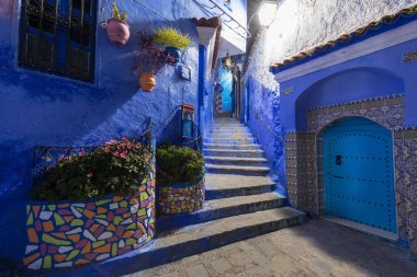 Chefchaouen, Fas, Afrika 'daki geleneksel ve tipik mimari detaylar ve mavi duvarlı ve çeşitli nesnelerle süslenmiş mavi Medine' nin güzel caddesi.. 