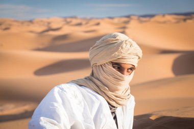 Sahara, Fas, 02-Ocak-2020. Turistik Merzouga Çölü 'nde sarıklı bir bedevinin portresi. Geleneksel kıyafetleriyle Tuareg 'li adam.