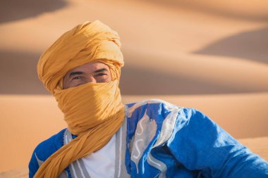 Sahara, Fas, 02-Ocak-2020. Popüler Merzouga çölünde kum tepecikli bir bedevi portresi. Geleneksel kıyafetleriyle Tuareg 'li adam.