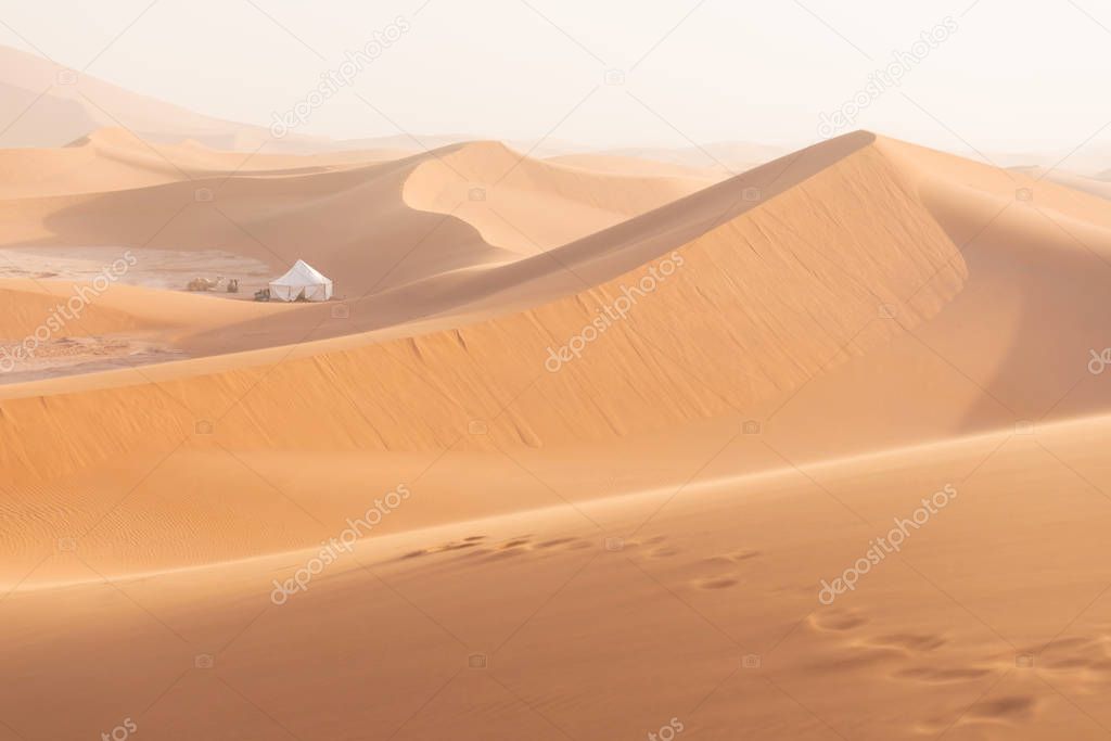 Desert landscape sand dunes at sunset sky near Merzouga, Morocco, Africa. Discovery and adventure travel concept. Sunlight over the desert dunes.