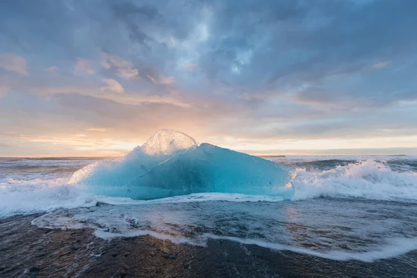 アイスランドの有名なダイヤモンドビーチの美しい夕日 この砂の溶岩ビーチには多くの巨大な氷の宝石がたくさんあり 氷河ラグーンの近くにありますジョクルサロンアイスランド南東部に黒い砂のビーチがある氷の岩 — ストック写真