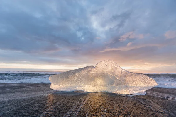 アイスランドの有名なダイヤモンドビーチの美しい夕日 この砂の溶岩ビーチには多くの巨大な氷の宝石がたくさんあり 氷河ラグーンの近くにありますジョクルサロンアイスランド南東部に黒い砂のビーチがある氷の岩 — ストック写真