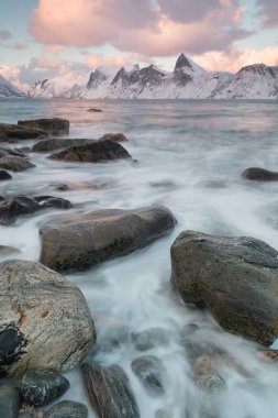 Karlı fiyortların ve dağ sırasının panoraması, Senja, Norveç İnanılmaz Norveç deniz manzarası popüler turistik cazibe merkezi. En ünlü seyahat yerleri. Muhteşem kış manzarası içinde güzel bir gün batımı