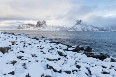 Karlı fiyortların ve dağ sırasının panoraması, Senja, Norveç İnanılmaz Norveç deniz manzarası popüler turistik cazibe merkezi. En ünlü seyahat yerleri. Muhteşem kış manzarası içinde güzel bir gün batımı