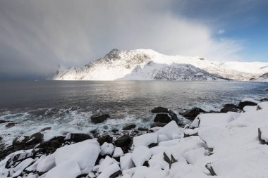 Karlı fiyortların ve dağ sırasının panoraması, Senja, Norveç İnanılmaz Norveç deniz manzarası popüler turistik cazibe merkezi. En ünlü seyahat yerleri. Muhteşem kış manzarası içinde güzel bir gün batımı