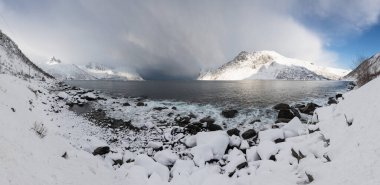 Panorama of snowy fjords and mountain range, Senja, Norway Amazing Norway nature seascape popular tourist attraction. Best famous travel locations. beautiful sunset within the amazing winter landscape clipart