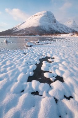 Kuzey Kutbu Norveç 'te karla kaplı dağlarda sabah erken saatlerde pembe parlayan ışık, süper geniş panoramik manzara. İskandinavya 'daki karlı dağın manzarası. Güzel manzara konsepti arka planı.