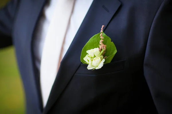 Groom boutonniere with feather and dried wildflowers in boho style