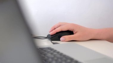Masada bilgisayar faresi olan kadın eli, yakın plan. 