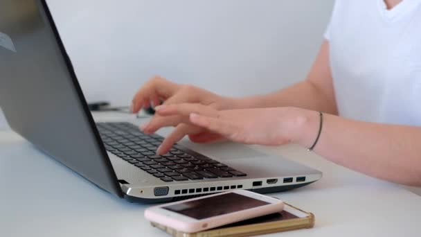 オフィスのデスクに座っている間にラップトップコンピュータを使用してビジネス女性の切り取られたショット — ストック動画