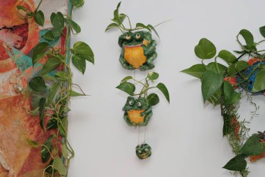 Eşarplı baykuşların kil figürleri ve bir kurbağa.