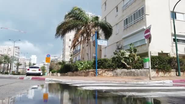 Israel Netanya March 2020 車は道路上の水たまりを通過します — ストック動画